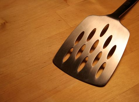 A spatula sitting on a wooden table.