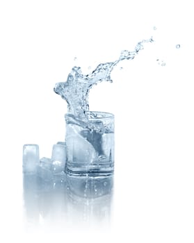 Few ice cubes near glass of splashing water on white background. Isolated with clipping path