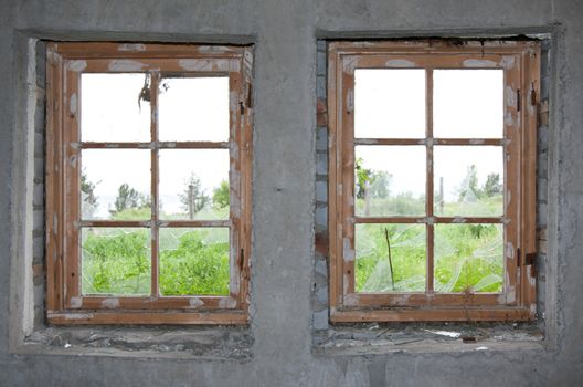 Two old windows, concrete wall and split glass