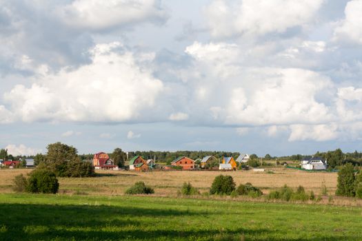 Rural lodges on background of the field with green herb