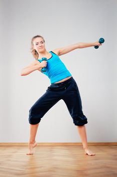 Young woman to training of athletic exercise with dumbbells