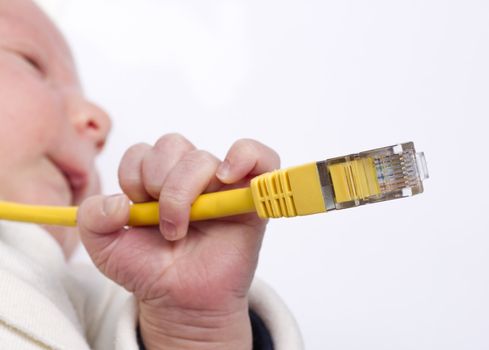 young baby holding yellow ethernet network cable