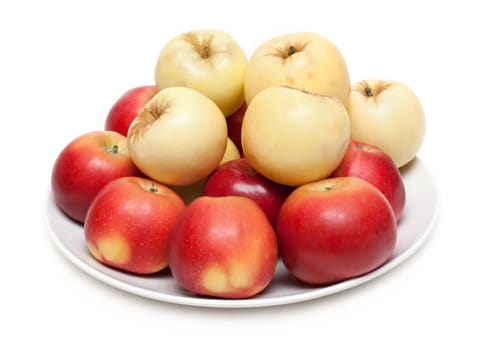 Red and yellow apple on plate on white background