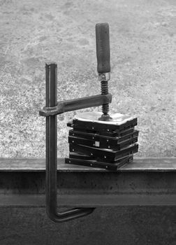compressed stack of hard disks by clamp. black and white shot