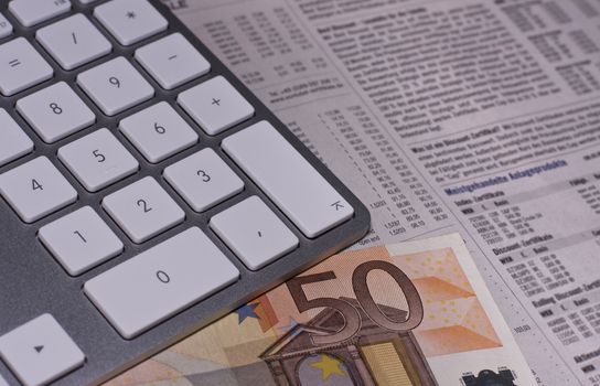 keyboard and euro bill on newspaper