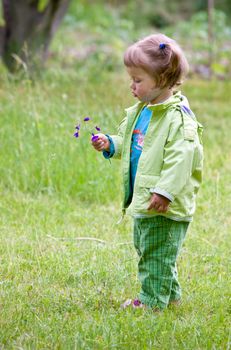 Little girl play with the flower in garden