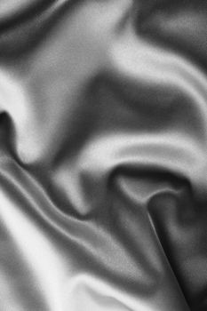 black satin background. A satiny fabric with beautiful light-shadow waves