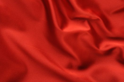 red satin background. A satiny fabric with beautiful light-shadow waves