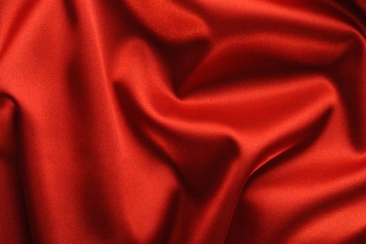 red satin background. A satiny fabric with beautiful light-shadow waves