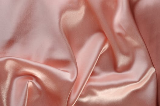 creamy satin background. A satiny fabric with beautiful light-shadow waves