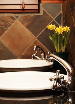 Beautiful bathroom with white sinks, granite tops and rustic tiles