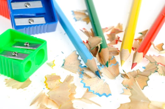 Color pencil and sharpener with a shaving. It is isolated on a white background
