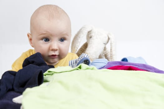 young child looking over many clothes
