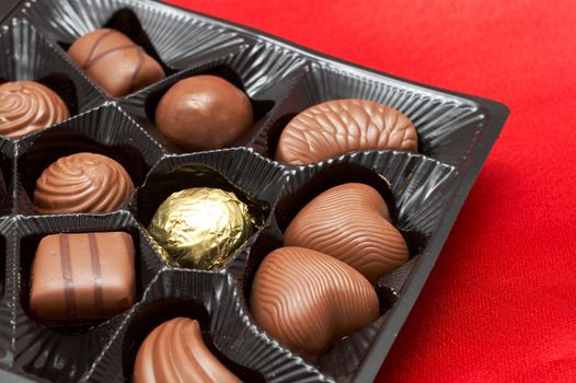 Assortment of Valentines chocolates in box on red silk