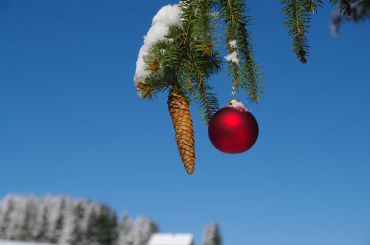 red bauble christmas ball ornament outside in a snowy winter scene