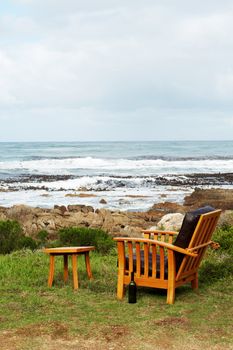 Wooden chair standing outside by the ocean. Perfect leisure scene