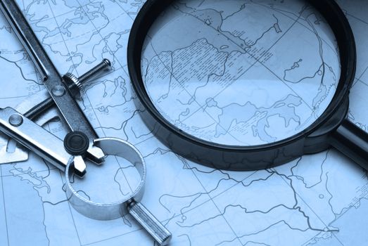 magnifier and card. Magnifying glass above a card of the world