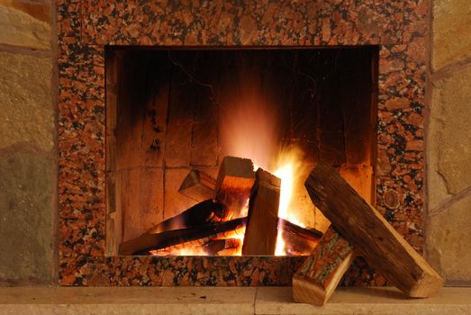 Fireplace. Flaring fire in a fireplace the reveted wild stone and a marble