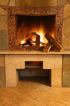 Fireplace. Flaring fire in a fireplace the reveted wild stone and a marble