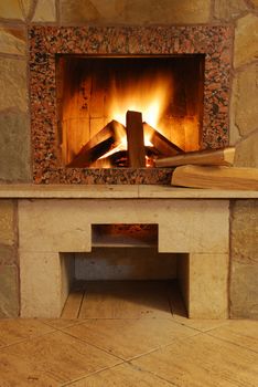 Fireplace. Flaring fire in a fireplace the reveted wild stone and a marble