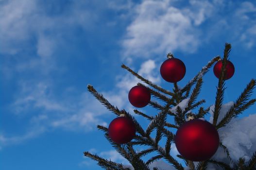 baubles  on a Christmas tree outside in a snowy landscape