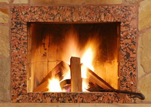 Fireplace. Flaring fire in a fireplace the reveted wild stone and a marble