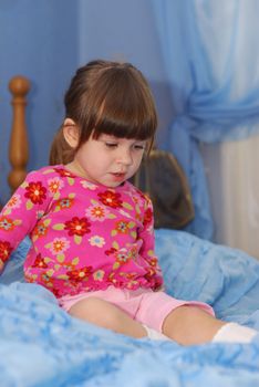 The little girl on a bed. The three-year child of the European nationality