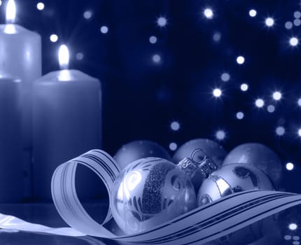 Christmas evening. A composition from candles, New Year's toys on a dark background