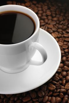 Cup of coffee. A background with coffee grains and a white cup. A photo close up 