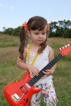 The girl with a guitar. The three-year child with a musical instrument