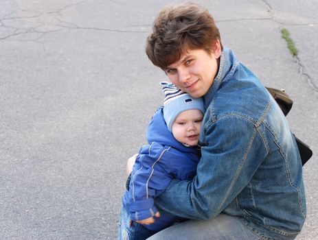 The father and the son. The European family, it is photographed on a background of asphalt