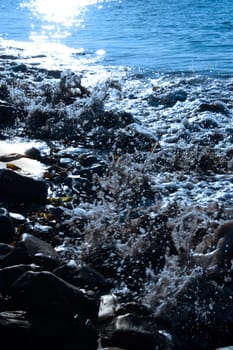 some rocks being washed over by the waves