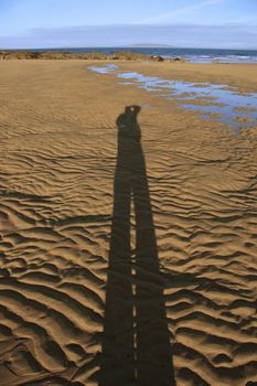 a tourists shadow taking in the beautifull irish scenery