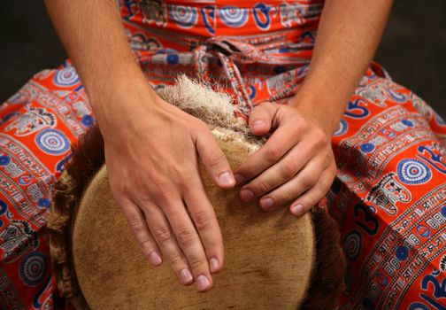 Man playing the djembe (nigerian drum) in studio