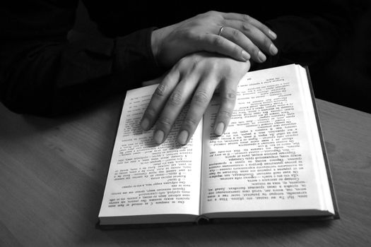 The male hand holds the open book