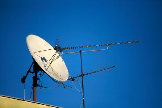 Satellite dish of TV on a roof on a background of the sky