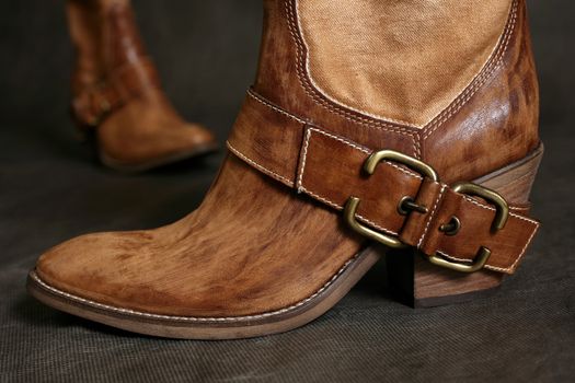 Female boots of the cowboy close-up on a dark background