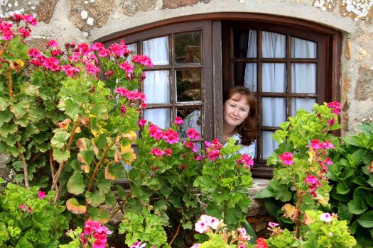 Young beautiful ginger-haired girl looking out of the window