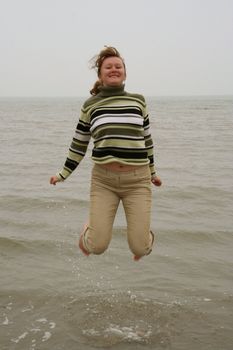 Beautiful happy girl jumping in the water