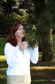 Beautiful young girl looking up and smiling near the pine tree