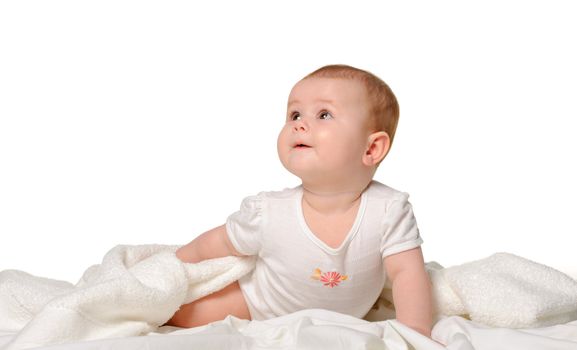 The baby on a bedsheet. Age of 8 months. It is isolated on a white background