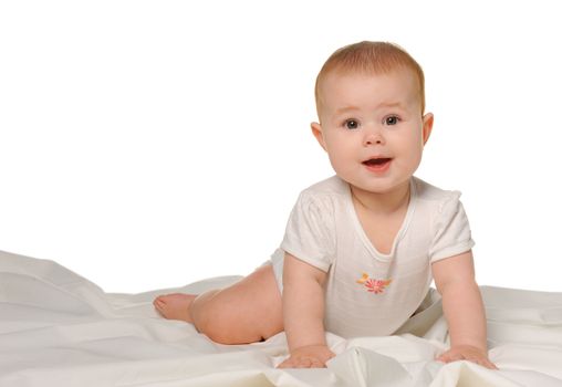 The baby on a bedsheet. Age of 8 months. It is isolated on a white background