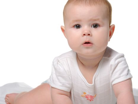 The baby on a bedsheet. Age of 8 months. It is isolated on a white background