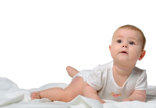 The baby on a bedsheet. Age of 8 months. It is isolated on a white background