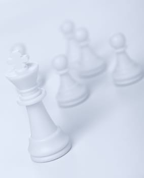 Chess figure - king. Concept of the leader. Pawns on blur a background