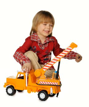 The little boy with a toy - a truck crane. It is isolated on a white background