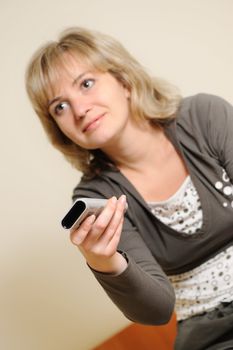 The woman with a television control panel. House conditions. Selective focus