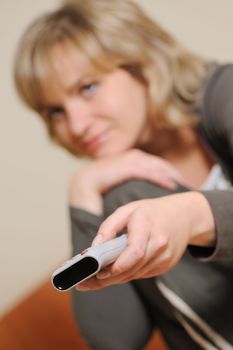 The woman with a television control panel. House conditions. Selective focus