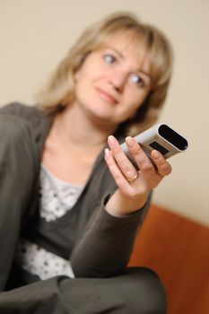 The woman with a television control panel. House conditions. Selective focus