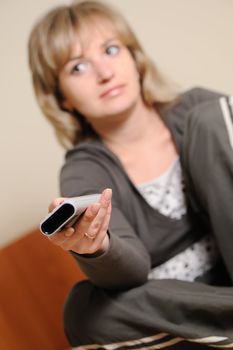 The woman with a television control panel. House conditions. Selective focus